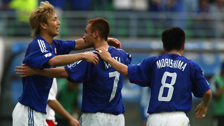 OSAKA - JUNE 14:  Hidetoshi Nakata (no.7) of Japan celebrates scoring the second goal with team-mates Takayuki Suzuki (left) and Hiroaki Morishima (right) during the FIFA World Cup Finals 2002 Group H match between Japan and Tunisia played at the Osaka-Nagai Stadium, in Osaka, Japan on June 14, 2002. Japan won the match 2-0. DIGITAL IMAGE. (Photo by Alex Livesey/Getty Images)